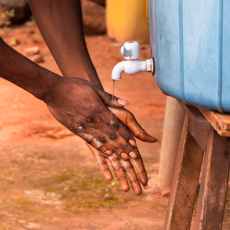 Child washing hands with clean water